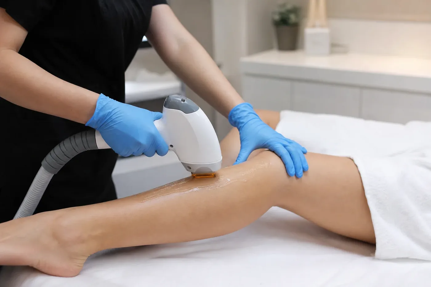Specialist applying laser hair removal on a client’s arm.